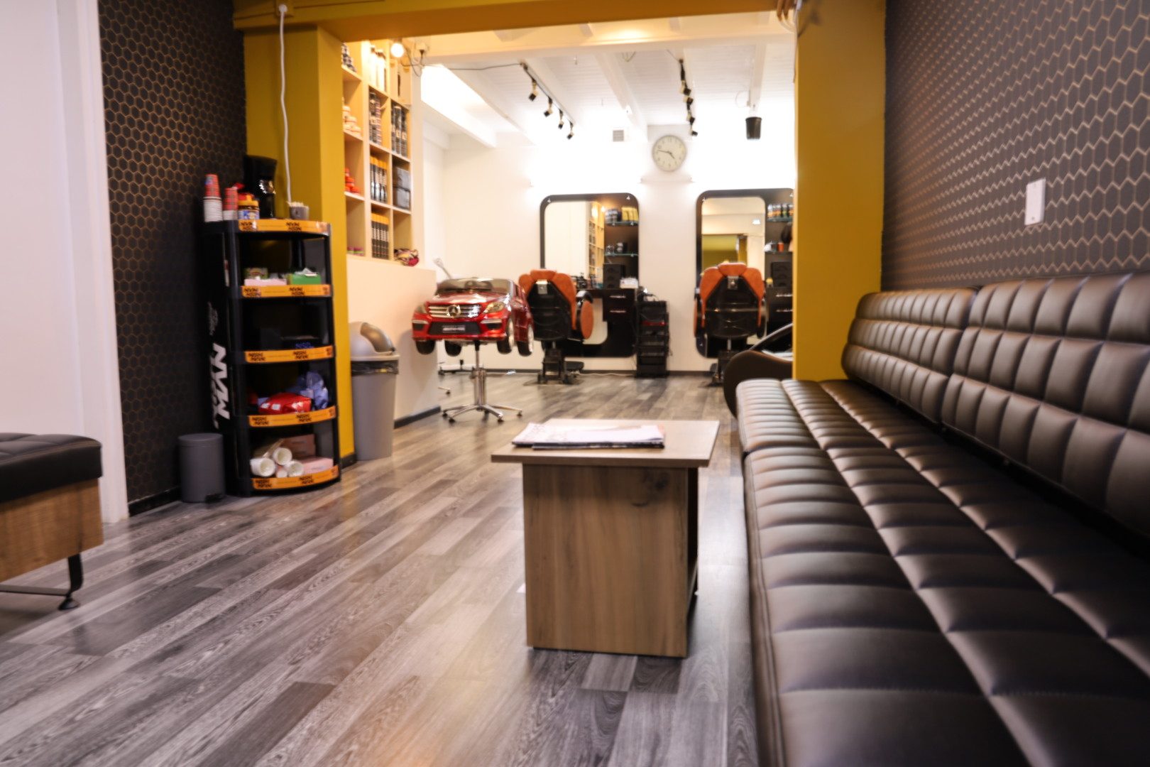 De salon van binnen, met stoelen, spiegels en de leren bank